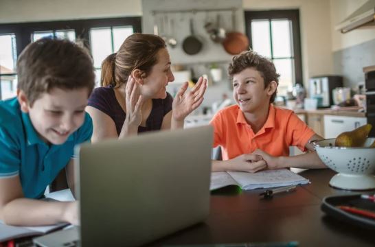 Parent supporting children with home education curriculum in the UK using online learning at home